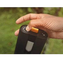 Eine Hand betätigt den Knopf eines schwarzen elektronischen Geräts mit USB-C-Anschluss.