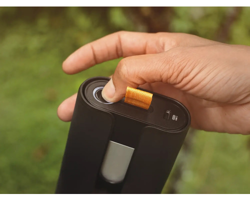 Eine Hand betätigt den Knopf eines schwarzen elektronischen Geräts mit USB-C-Anschluss.