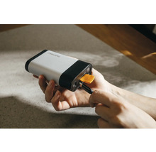 Fiskars Logo, eine Person schliesst ein USB-Kabel an eine Powerbank an.