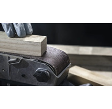 Nahaufnahme eines Bandschleifers beim Glätten eines Holzstücks