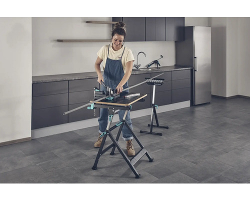 Frau arbeitet mit einer Werkbank und einer Schneidlade in einem Raum.