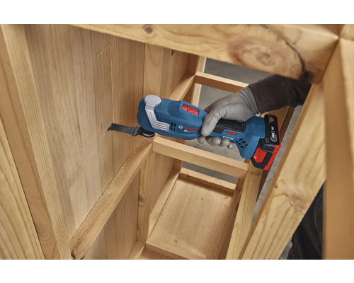 Bosch 18 Volt Akku-Multicutter beim Sägen eines präzisen Tauchschnitts in ein Holzgestell.