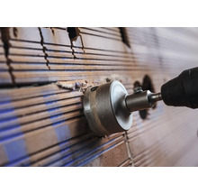 Lochsäge bohrt ein Loch in eine Ziegelwand