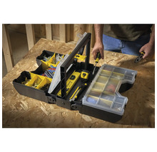 Offene schwarze Werkzeugkiste mit Werkzeugen und Zubehör, im Hintergrund eine Person.