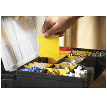 Offene Werkzeugkiste mit verschiedenen Fächern und einer Hand, die einen gelben Einsatz hält.