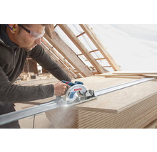 Handwerker sägt mit einer Handkreissäge auf einer Führungsschiene Holzplatten zu. Bosch Logo.