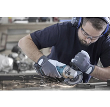 Mann beim Schleifen von Metall mit einem Winkelschleifer, Funken fliegen