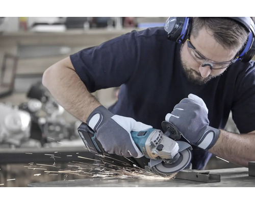 Mann beim Schleifen von Metall mit einem Winkelschleifer, Funken fliegen