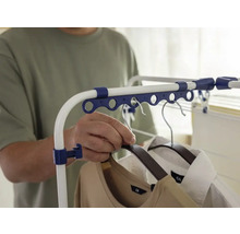 Person hängt Kleidung auf einen Wäscheständer.