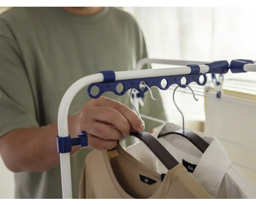 Person hängt Kleidung auf einen Wäscheständer.