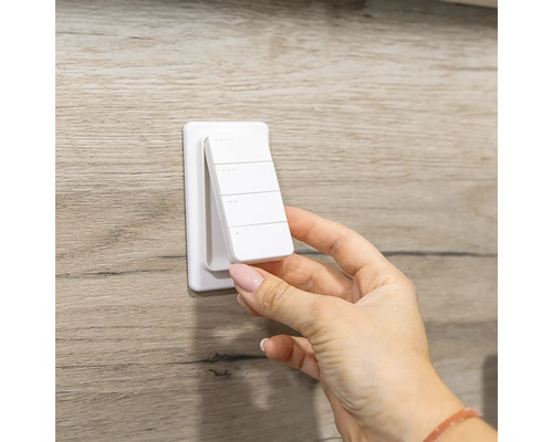 Weiße magnetische Fernbedienung für Smart Home Wandschalter mit vier Tasten wird von der Wandhalterung abgenommen.