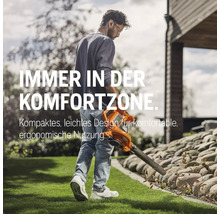 Mann benutzt einen Laubsauger im Garten.