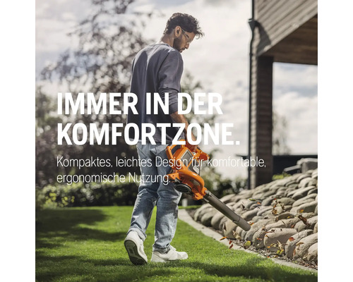 Mann benutzt einen Laubsauger im Garten.