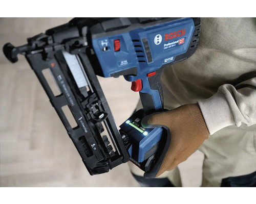 Bosch Professional Akku-Nagler GNH 18V-64-2 wird von einer Person mit Arbeitshandschuh gehalten.