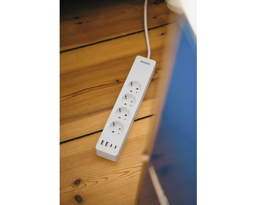 Smarte Mehrfachsteckdose von Osram mit vier Steckplätzen und vier USB-Anschlüssen auf einem Holzboden.