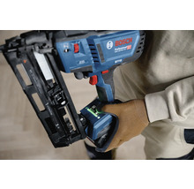 Bosch Professional Akku-Nagler GNH 18 Volt 64-2 M mit Benutzeroberfläche wird von einer Person mit Arbeitshandschuh gehalten.
