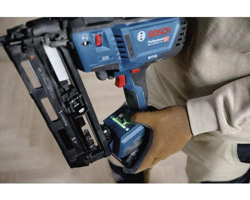 Bosch Professional Akku-Nagler GNH 18 Volt 64-2 M mit Benutzeroberfläche wird von einer Person mit Arbeitshandschuh gehalten.