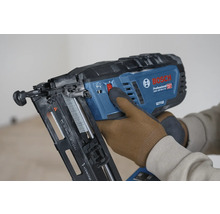 Bosch Professional Akku-Nagler GNH 18V-64-2 M wird von einer Person mit Arbeitshandschuhen bedient.