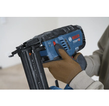 Bosch Professional Akku-Nagler wird von einer Person mit Arbeitshandschuhen bedient.