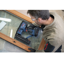 Handwerker verwendet einen Bosch Professional Akku-Nagler an einem Holzfensterrahmen.