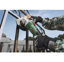 Person bearbeitet einen Metallzaun mit einem Bosch Akkumulator Winkelschleifer PWS 18V-70 im Freien mit Funkenflug.