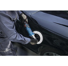 Eine Person poliert die Karosserie eines schwarzen Autos mit einer Bosch Akku-Poliermaschine und einem weißen Polierpad.