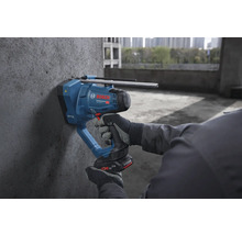 Bosch Professional Akku-Betonnagler wird von einer Person mit Arbeitshandschuhen an einer Betonwand auf einer Baustelle verwendet.