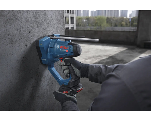 Bosch Professional Akku-Betonnagler wird von einer Person mit Arbeitshandschuhen an einer Betonwand auf einer Baustelle verwendet.