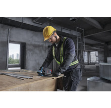 Handwerker mit Bosch Akku-Blechschere trennt Gewindestangen auf einer Baustelle. Er trägt Helm, Schutzbrille und Warnweste.