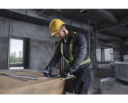 Handwerker mit Bosch Akku-Blechschere trennt Gewindestangen auf einer Baustelle. Er trägt Helm, Schutzbrille und Warnweste.