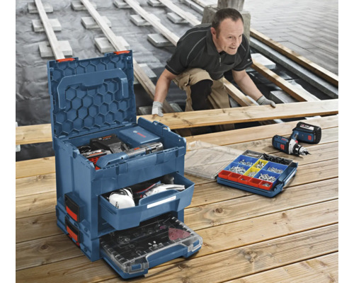 Handwerker arbeitet an Holzterrasse mit Bosch L-BOXX Werkzeugkoffersystem inklusive Schubladen und Kleinteilemagazin.