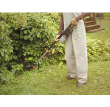 Person bedient eine Akku-Heckenschere im Garten.