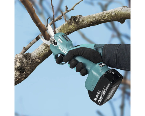 Akku-Astschere von Makita mit bürstenlosem Motor beim Schneiden eines Baumzweigs mit einem 18 Volt Akku.