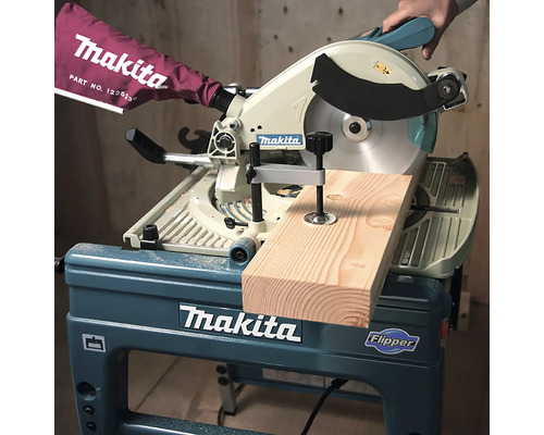 Makita Tisch-, Kapp- und Gehrungssäge Flipper beim Schneiden eines Holzbretts mit einer Spannvorrichtung.