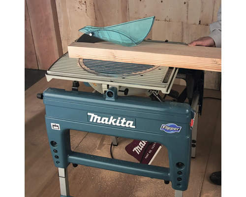 Makita Tisch-, Kapp- und Gehrungssäge Flipper im Einsatz beim Sägen eines Holzbretts.