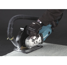 Makita Mauernutfräse mit Staubabsaugung und Arbeitshandschuh bei der Bearbeitung einer Steinplatte