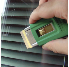 Eine Hand benutzt einen Glasschaber mit Klinge zur Fensterreinigung.