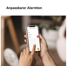Eine Person hält ein Smartphone, das eine Alarmton-Einstellungsseite anzeigt.