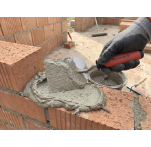 Vermörteln von Ziegelsteinen mit einer Maurerkelle