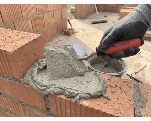 Vermörteln von Ziegelsteinen mit einer Maurerkelle