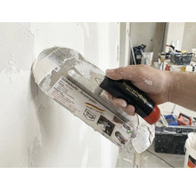 Glättkelle Superglatt mit Griff in der Hand beim Verputzen einer Wand