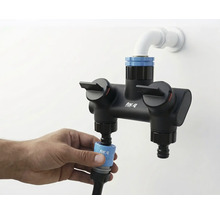 Aufnahme einer for_q Doppelbatterie mit Wasseranschluss und Hand, die einen Schlauch befestigt.