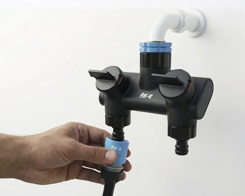 Aufnahme einer for_q Doppelbatterie mit Wasseranschluss und Hand, die einen Schlauch befestigt.