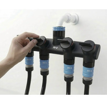 Gartenschlauchverteiler mit vier Anschlüssen und Hand, die einen der Hähne bedient