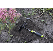 Gartengerät mit Rechen und Hacke im Beet neben einer Pflanze