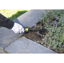 Eine Person verwendet eine Gartenkralle zum Auflockern der Erde in einem Hochbeet.