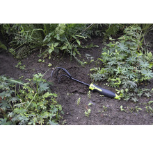 Gartenkralle im Beet zwischen Pflanzen