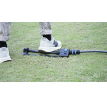 Gartenregner auf Rasen mit Fuß zum Größenvergleich.