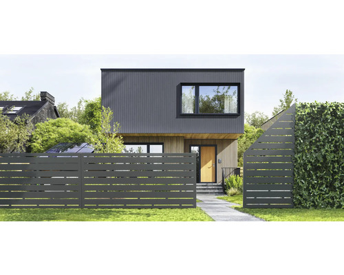 Modernes Haus mit Holz- und Paneelfassade, davor ein Metallzaun mit horizontalen Aussparungen, Gartenweg und Hecke.