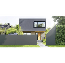 Modernes Haus mit dunkelgrauer Fassade oben und heller Holzverkleidung unten, mit grauem Sichtschutzzaun und einer Hecke im Vordergrund.